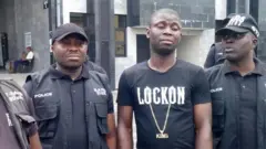 abategetsi bavuga ko Gracious David-West (hagati) yabanza kuboha abo yica agaca abaniga