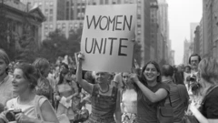 Uma mulher mais idosa e uma jovem seguram um cartaz dizendo 'Mulheres Unidas', enquanto marcham, com outras mulheres, pela Quinta Avenida, em Nova York (EUA)