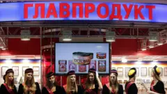 Вывеска Главпродукт и реклама консервов, ниже - много девушек в униформе