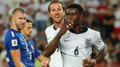 Engleski reprezentativac Mark Guei slavi postizanje gol sa Harijem Kejnom, u pozadini je fudbaler Srbije Strahinja Pavlović