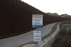 Placa perto de muro diz que não se pode ultrapassar área e que ali é território americano