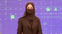 
خبرنگارزن تلویزیون خصوصی طلوع در حال اجرای برنامه با ماسک صورت
