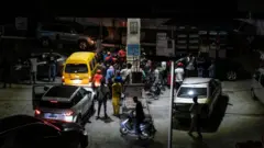 People wait to refill their fuel tanks at a petrol station in Lagos, on September 4 2024.