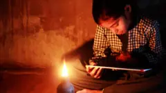 Menina lendo à luz de candeeiro