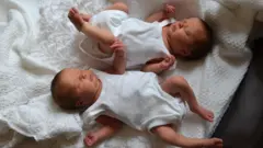 Meninas recém-nascidas, com cinco dias de vida, dormem sobre um cobertor