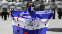 Una manifestante muestra una bandera ensangrentada durante una protesta contra el gobierno del presidente nicaragüense Daniel Ortega en Managua, el 16 de septiembre de 2018.