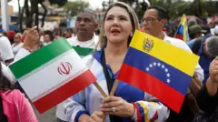 Una venezolana en una marcha en Caracas con la bandera de su país y la de Irán.
