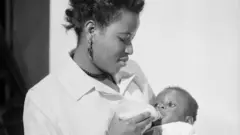 Aworan iya to n fun ọmọ ni ounjẹ lati inu ife ijẹun ọmọde