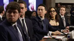 (Da esquerda para a direita) Jason Citron, CEO do Discord; Evan Spiegel, CEO da Snap; Shou Zi Chew, CEO do TikTok; Linda Yaccarino, CEO do X; e Mark Zuckerberg, CEO da Meta, depõem perante o Comitê Judiciário do Senado, no prédio Dirksen do Senado, em Washington (EUA), em 31 de janeiro de 2024. Todos vestem ternos pretos e estão sentados lado a lado à mesa.