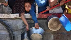 Gazatíes esperando la llegada de alimentos