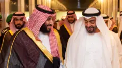 صورة تظهر ولي العهد السعودي والرئيس الإماراتي يسيران جنبًا إلى جنب مبتسمَين.