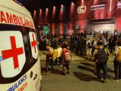 Ambulância e pessoas em frente a pavilhão da COP