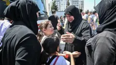 In this file photo taken on August 06, 2019, family and friends say goodbye as Syrian refugee voluntarily board buses returning to neighbouring Syria in the Esenyurt district of Istanb