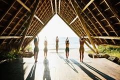 un grupo de mujeres meditando frente al mar.