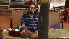 Hombre en India siendo asistido por un tanque de oxígeno.