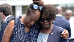 mulheres negras chorando em velório das vítimas do tiroteio em Buffalo