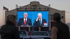 Espectadores nas ruas assistem a um debate presidencialgame365 bet2020 entre Joe Biden e Donald Trump, sendo transmitidogame365 bettelão