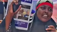 Umugore yambaye ibitukura n'ivyirabura , ari mu myiyerekano 