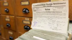 Um cartão em cima de uma pilha de pedidos de filiação ao Partido Nazista nos Arquivos Federais da Alemanha, em Berlim, em 17 de abril de 2007.