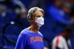Un hombre con una camiseta azul con la palabra "Florida" estampada en el pecho y cubierto con una mascarilla en un recinto deportivo en Gainesville, Florida.