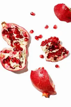 Diversas romãs abertas com as sementes espalhadas