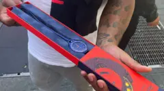 Um cliente mostra seu relógio Audemars Piguet x Swatch Royal Pop recém-comprado do lado de fora de uma loja Swatch na Times Square, em Nova York