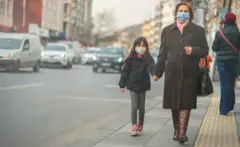 ከእናቷ ጋር እየተራመደች ያለች ታዳጊ