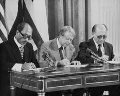 الرئيس المصري الأسبق أنور السادات رئيس مصر، و الرئيس الأمريكي الأسبق جيمي كارتر، ورئيس وزراء إسرائيلي الأسبق مناحيم بيغن يوقعون اتفاقية كامب ديفيد في البيت الأبيض في واشنطن، 17 سبتمبر/ أيلول 1978.