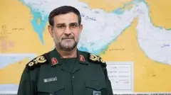 Alireza Tangsiri wear im force uniform wey be deep green, e wear glasses as e look in side camera wit strong face.