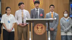 Juraluk Kunaruk (primeiro da direita), diante do parlamento tailandês enquanto o deputado Nitikorn Bunyakulcharoen (ao centro) se dirige aos legisladores sobre a onda de fraudes em torno de ingressos para shows do BTS
