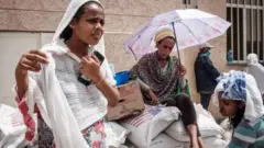 እርዳታ እየተቀበሉ ያሉ ሴቶች