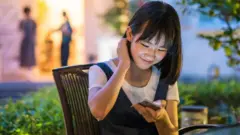 مراهقة صينية تستخدم الهاتف