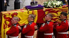 The Bearer Party from Queen's Company, 1st Battalion Grenadier Guards, carries the coffin of Queen Elizabeth II, draped in the Royal Standard with the Imperial State Crown placed on top, into Westminster Hall, London on 14 September 2022