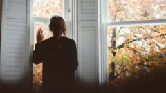 picture of lady looking out of a window