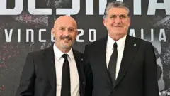 İki siyah beyaz takım elbiseli kişi var fotoğrafta. 