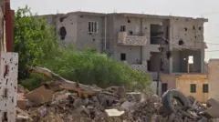 مبانٍ تضررت بسبب الحرب في إحدى ضواحي طرابلس في 28 مايو/أيار 2024 - الصورة أخذت نهاراً