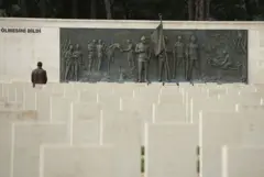 Mezar taşları önünde duran bir adam