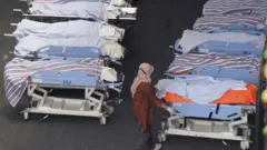A row of covered bodies in the nearby hospital