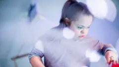 Menina que tem síndrome de Down aparece brincando