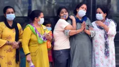 అంత్యక్రియల దగ్గర కోవిడ్‌ మృతుడి కుటుంబం