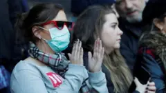 A fan wears a face mask inside Murrayfield Stadium in Edinburgh during a Six Nations match