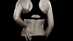 Una mujer padece de lumbalgia.