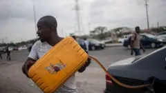 Man wey dey put fuel from jerrycan inside im car.