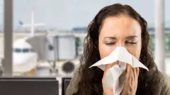 Woman coughing at an airport