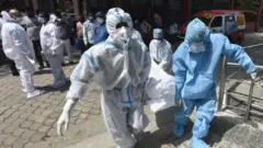 Doctors wearing Personal Protective Equipment (PPE) are seen inside Shehnai Banquet Hall, temporarily converted into isolation wards for COVID-19 patients, amid the ongoing surge in coronavirus cases in New Delhi on April 12, 2021.