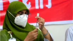 সিনোফার্মের টিকা দেয়ার প্রস্তুতি নিচ্ছেন এক স্বাস্থ্যকর্মী।