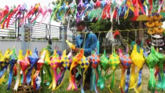 Seorang pengrajin menjalin pita jepang untuk membuat ketupat hias Lebaran di Kota Dumai, Dumai, Riau, Rabu (13/5/2020)