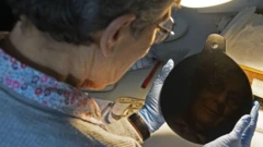 ดร. เอลิซาเบธ ฮีลีย์ นักโบราณคดีชาวอังกฤษ ขณะส่องกระจกออบซิเดียน