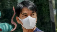 A man wearing a protective mask walks outside a department store in Bangkok, Thailand.
