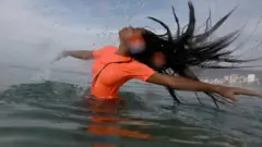 ब्याले नर्तकी अनुष्का जोए जेम्स ब्रजिलमा समुद्रको पानीमा नाच्दै।